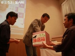 プレゼント抽選会の当選番号を引く浦河軽種馬生産振興会の谷川会長