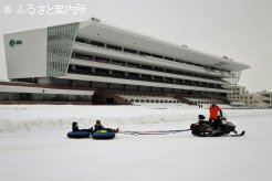雪に覆われたダートコースを疾走するスノーラフティング体験