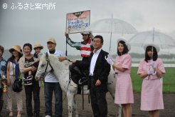大雨の中、笑顔の口取り