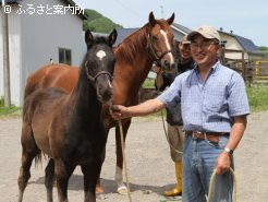 ライズラインの生産者・土井和則さん。 馬は土井牧場の繁殖牝馬2頭のうちの1頭・ユアライフスタイルと、今年生まれた当歳馬(牡、父ロージズインメイ)