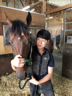 「目標は早くG1馬に乗ること」だと話す、新人スタッフの田中恭さん。伊藤厩舎長もその頑張りを高く評価する。