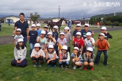 落札された馬をバックに記念撮影
