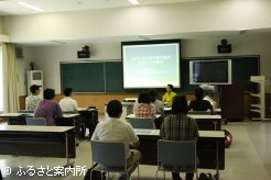 研修所講義室で研修内容の説明を受ける参加者