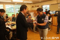 最優秀賞を受賞した(有)北島牧場。山野辺啓場長からトロフィーが贈られニッコリ