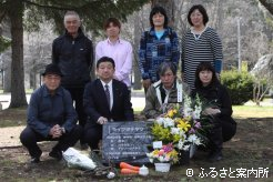 墓石を囲んで記念撮影。前列左端が生産者の谷岡正次さん