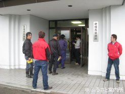 受付の順番待ちをしながら情報交換をする育成牧場関係者