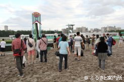 プレゼントされた小瓶にダートの砂を入れ持ち帰るファンの姿も