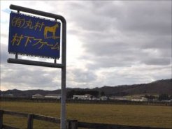 (有)丸村村下ファームの看板と放牧地