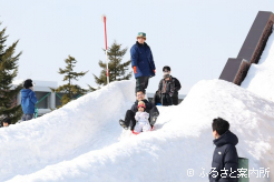 雪のすべり台は家族連れで賑わっていた