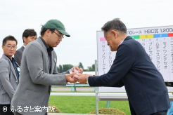 岡田牧雄氏からトロフィーが授与された